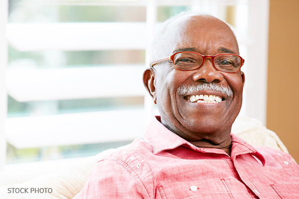 Smiling man wearin glass and wearing a pink shirt