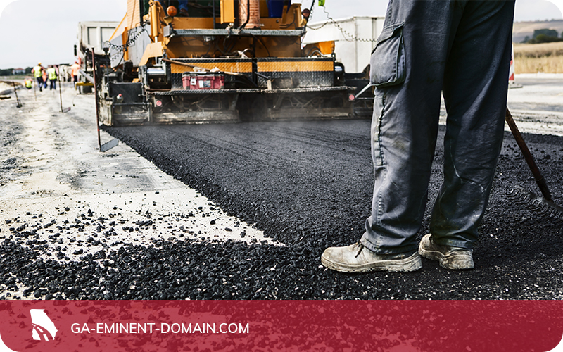 A highway being built and paved with asphalt.