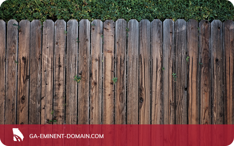 A privacy fence in a backyard made of wooden boards.